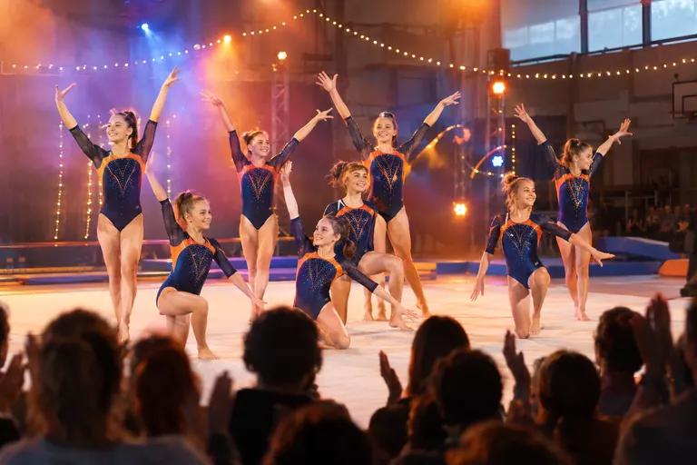 Des gymnastes en justaucorps scintillants saluent le public lors du gala